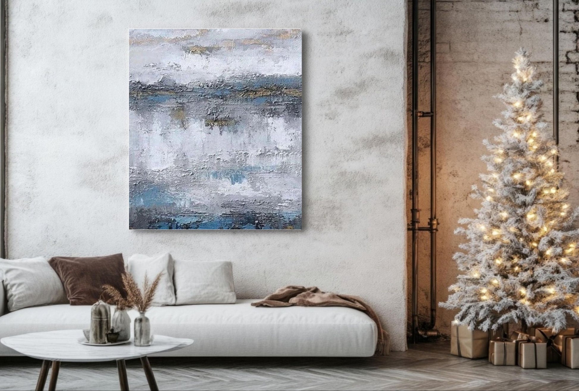 a large abstract painting on the wall, a white sofa, and a decorated Christmas tree.