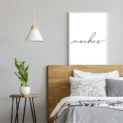 Modern bedroom with wooden headboard, white bedding, and 'noches' wall art.