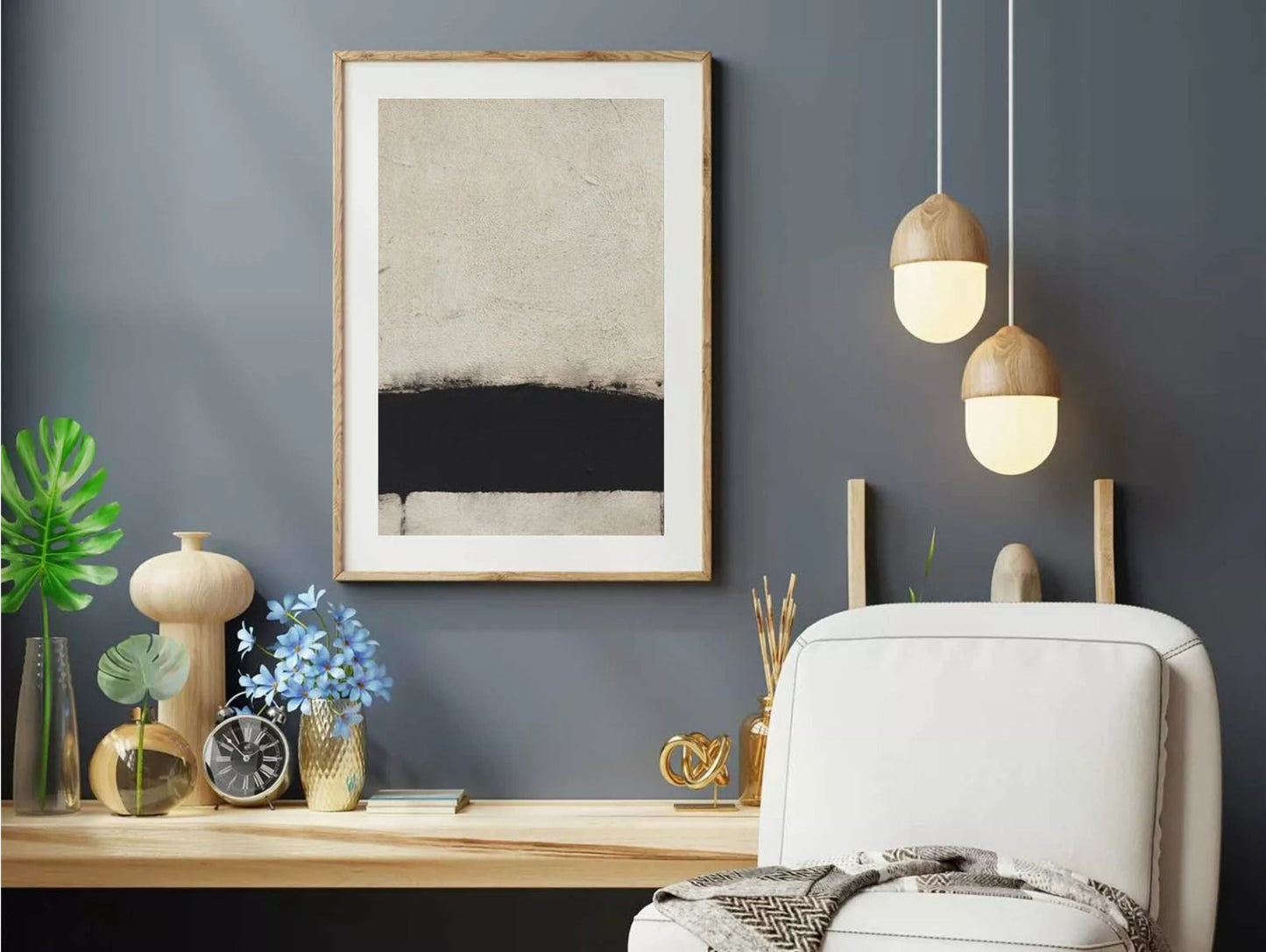 Modern home office with gray wall, framed abstract art, desk, and chair.