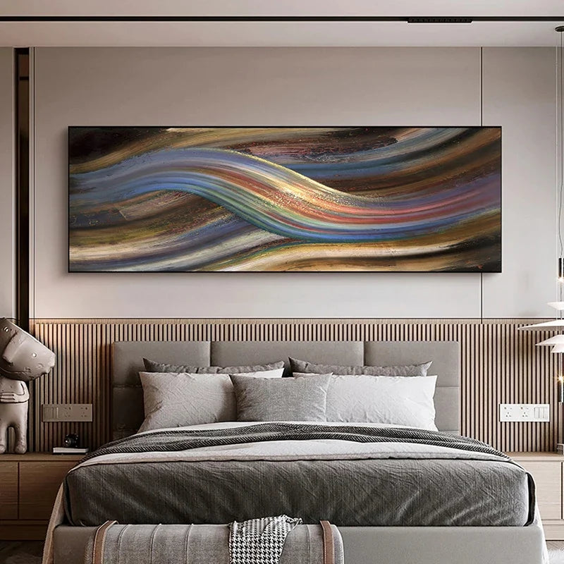 A large rectangular abstract wall art piece with flowing wavy bands of blue, gold, brown, red, and cream, displayed above a neatly made bed in a modern bedroom.