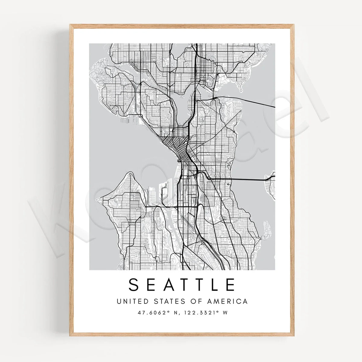 A framed minimalist city map print of Seattle, United States, featuring a black street grid on a light gray background with the city name and coordinates printed below, set in a light wood frame against a white wall.