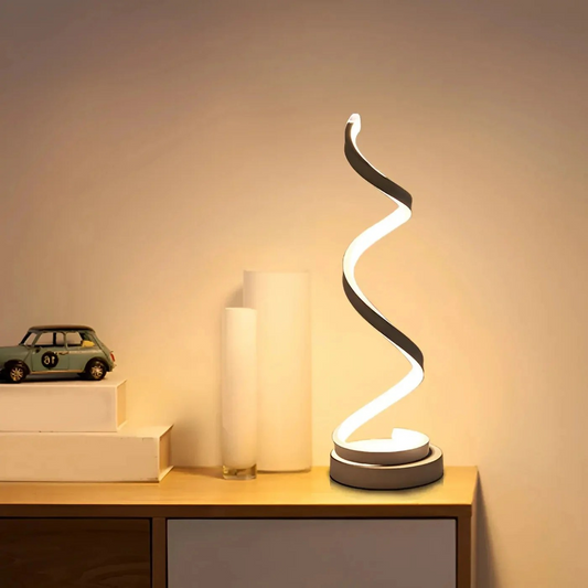 Modern table lamp with a curved design on a wooden surface.