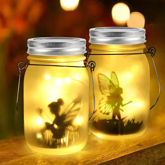 Two illuminated jars with fairy silhouettes on a blurred background