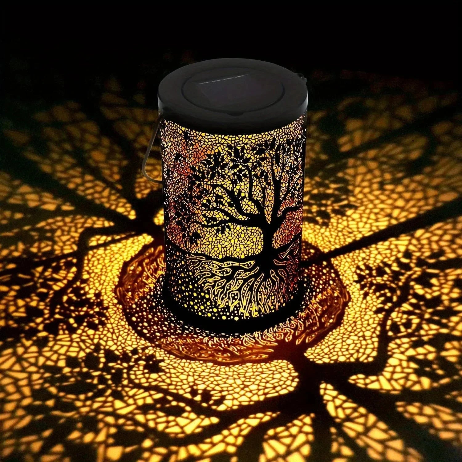 Decorative lamp casting tree shadows on a dark background